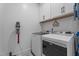 Laundry room with white cabinets, overhead shelf with sign, and washer and dryer at 33 Davidson St, Clayton, NC 27527