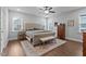 Spacious main bedroom featuring a large bed, neutral tones, wood flooring, and lots of natural light from the windows at 33 Davidson St, Clayton, NC 27527