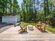 Backyard deck with wooded scenery, outdoor seating, and adjacent garage at 3421 Angus Rd, Durham, NC 27705