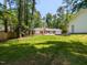Grassy backyard view of ranch style home with garage and screen porch at 3421 Angus Rd, Durham, NC 27705