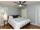 Cozy bedroom featuring hardwood floors, ceiling fan, and bright windows at 3421 Angus Rd, Durham, NC 27705