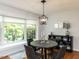 Dining area with a modern light fixture, round table, and large window with view of outdoors at 3421 Angus Rd, Durham, NC 27705