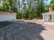 View of long driveway, detached garage, backyard deck, and part of rear facade at 3421 Angus Rd, Durham, NC 27705