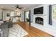 Spacious living room with hardwood floors, fireplace, and open access to the kitchen and outdoor patio at 3421 Angus Rd, Durham, NC 27705