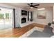 Bright living room featuring hardwood floors, a fireplace, and sliding glass doors leading to the patio at 3421 Angus Rd, Durham, NC 27705