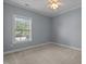 Bedroom with neutral carpeting, ceiling fan, and natural light from the large window at 39 Mcguire Ln, Clayton, NC 27527