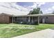 A spacious backyard view of the home, with a screened-in porch and partial grass at 403 E Mcpherson Dr, Mebane, NC 27302
