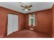 Cozy bedroom featuring red walls, a ceiling fan, closet, and window providing a warm and private space at 403 E Mcpherson Dr, Mebane, NC 27302