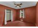 Cozy bedroom featuring red walls, a ceiling fan, closet, and window providing a warm and private space at 403 E Mcpherson Dr, Mebane, NC 27302
