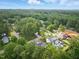 An aerial view captures a lush, green neighborhood with a mix of beautiful homes, framed by mature trees and manicured landscaping at 5013 Coronado, Raleigh, NC 27609