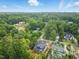 An aerial view of a new home under construction, nestled within a verdant neighborhood with mature trees and established homes at 5013 Coronado, Raleigh, NC 27609