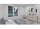 Bright bedroom featuring a stylish bed, neutral decor, and large windows with a view of the trees at 5013 Coronado, Raleigh, NC 27609