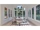 Bright dining room with high ceilings, statement light fixture, and views of the natural landscape at 5013 Coronado, Raleigh, NC 27609