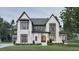 Striking two-story home showcasing a modern aesthetic with its brick facade and sleek black-trimmed windows at 5013 Coronado, Raleigh, NC 27609