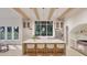 Bright open kitchen with island seating, modern appliances, wooden beams, and large windows offering outdoor views at 5013 Coronado, Raleigh, NC 27609