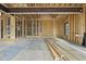 Framed-out living room showcasing the beginning stages of a new construction home, complete with wooden beams and window framing at 5013 Coronado, Raleigh, NC 27609