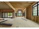 Vast, unfinished living area with exposed beams, and black window frames offering generous light at 5013 Coronado, Raleigh, NC 27609