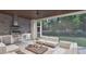 Outdoor kitchen and lounge area with seating, grill, and serene views of the yard at 5013 Coronado, Raleigh, NC 27609