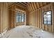 Unfinished room with exposed wood framework, windows, and a new subfloor, ready for your customization at 5013 Coronado, Raleigh, NC 27609
