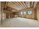 Spacious, unfinished room featuring wood framework and large windows offering natural light and customizable space at 5013 Coronado, Raleigh, NC 27609
