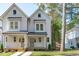 Charming two-story home featuring a welcoming porch, gray siding and black metal roof accents at 5053 Lundy Dr # 101, Raleigh, NC 27606