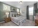 Charming bedroom with an accent wall, a large bed, and windows providing natural light at 5060 Trotter Dr, Raleigh, NC 27603