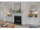 Cozy living room featuring a fireplace, built-in cabinets, and decorative mirrors at 5060 Trotter Dr, Raleigh, NC 27603