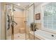 Elegant bathroom with a glass-enclosed shower, soaking tub, and tiled walls at 5405 Bluet Ct, Holly Springs, NC 27540