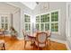 Sunlit dining area with hardwood floors, a round table, seating for four, and large shuttered windows at 5405 Bluet Ct, Holly Springs, NC 27540