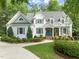 Charming two-story home features manicured landscaping, a blue front door, and a welcoming front porch at 5405 Bluet Ct, Holly Springs, NC 27540