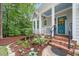 Welcoming front entrance with a cheerful blue door, brick steps, and well-kept landscaping at 5405 Bluet Ct, Holly Springs, NC 27540