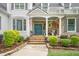 This home has a cozy front porch with stone pillars and a beautiful blue door perfect for relaxation at 5405 Bluet Ct, Holly Springs, NC 27540