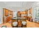 Spacious kitchen with an island, seating, custom wood cabinetry, stainless steel appliances, and hardwood flooring at 5405 Bluet Ct, Holly Springs, NC 27540