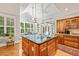 A spacious kitchen island with a cooktop, seating, storage, and pendant lighting creates a focal point at 5405 Bluet Ct, Holly Springs, NC 27540