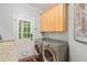 Well-equipped laundry room with modern washer and dryer, sink, and stylish cabinets at 5405 Bluet Ct, Holly Springs, NC 27540