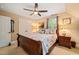 Well-lit main bedroom with a ceiling fan, bedside tables, closet, and a large window at 5405 Bluet Ct, Holly Springs, NC 27540