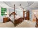 Serene main bedroom features a four-poster bed, tray ceilings, and ample natural light at 5405 Bluet Ct, Holly Springs, NC 27540