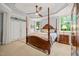 Spacious bedroom featuring a tray ceiling, a four-poster bed, and a nightstand at 5405 Bluet Ct, Holly Springs, NC 27540