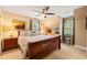 Well-lit main bedroom with a ceiling fan, bedside tables, and a large window at 5405 Bluet Ct, Holly Springs, NC 27540