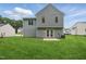 Exterior home view showcasing a well-maintained lawn and a cozy back patio at 5408 Gunnette Dr, Raleigh, NC 27610