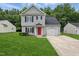 Charming two-story home featuring a well-manicured lawn, a bright red front door, and an attached one-car garage at 5408 Gunnette Dr, Raleigh, NC 27610