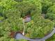 A bird's eye view of a house nestled within a vibrant, lush, tree-filled landscape at 5805 Laurel Rock Ln, Raleigh, NC 27613