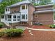 Backyard featuring a brick home, stone patio and walkway surrounded by mature landscaping at 5805 Laurel Rock Ln, Raleigh, NC 27613