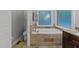 Bathroom with a large soaking tub with tile surround and a frosted window for natural light at 5805 Laurel Rock Ln, Raleigh, NC 27613
