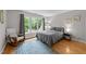 Bedroom with hardwood floors, neutral walls, rocking chair, and a large window offering ample natural light at 5805 Laurel Rock Ln, Raleigh, NC 27613