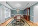 Formal dining room features elegant chandelier, tray ceiling, hutch and large windows at 5805 Laurel Rock Ln, Raleigh, NC 27613