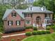 Charming brick home with a well-maintained lawn, attractive landscaping, and classic shutters on all the windows at 5805 Laurel Rock Ln, Raleigh, NC 27613