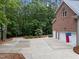 Exterior of a brick home with an attached garage, basketball hoop, and wooded surroundings at 5805 Laurel Rock Ln, Raleigh, NC 27613