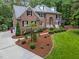 Beautiful brick home boasts manicured landscaping, healthy lawn, and a welcoming walkway to the front door at 5805 Laurel Rock Ln, Raleigh, NC 27613