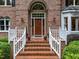 Elegant brick entryway showcases a beautiful wood door with sidelights and decorative planters at 5805 Laurel Rock Ln, Raleigh, NC 27613